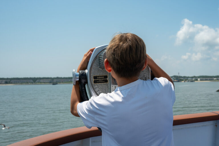A young passenger on board the Cape May - Lewes Ferry looks through a View Finder as the Ferry departs Lewes Delaware