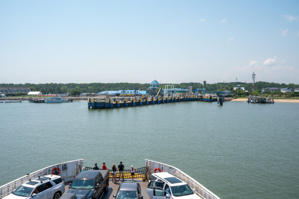 A view from an arriving Cape May - Lewes Ferry vessel as she approaches the Lewes Ferry Terminal to dock and unload passengers and vehicles. The view of the green where concerts Grain on the Rocks holds their summer concert series "Rocking the Docks" and tables along the boardwalk for visitors to enjoy.