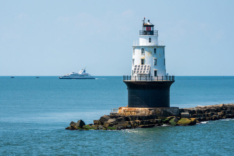 Cape May - Lewes Ferry vessel MV Delaware sailing on Delaware Bay sailing into the Harbor of Refuge in the background of the lighthouse.