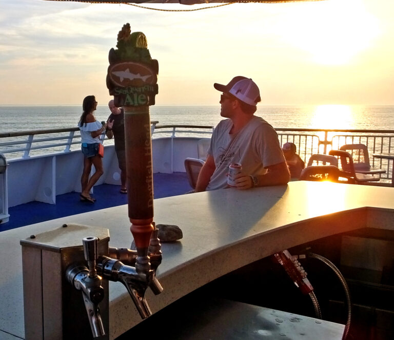 A passenger sits at the Lido Bar on MV New Jersey watching the sunset as the Ferry crosses Delaware Bay