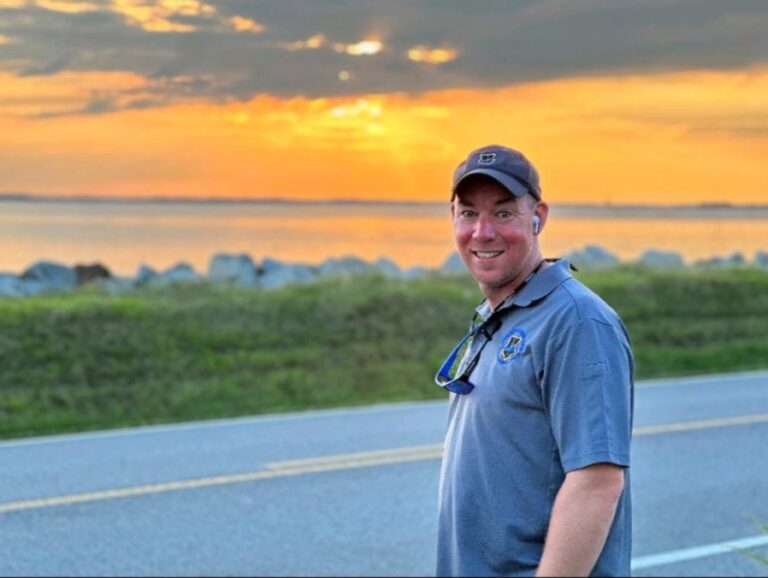 Port Engineer Mike Lynch Poses near the Shoreline at sunset.