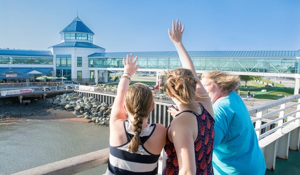 3 friends waving to their loved ones as the ferry pulls away from the Cape May Terminal