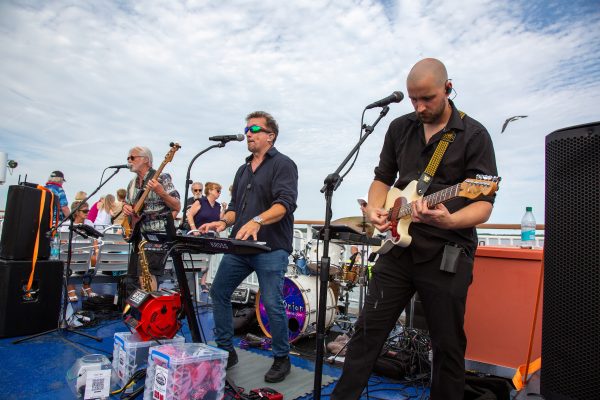 A singer and guitarists from Glass Onion perform on the Ferry during the Rock the Boat event