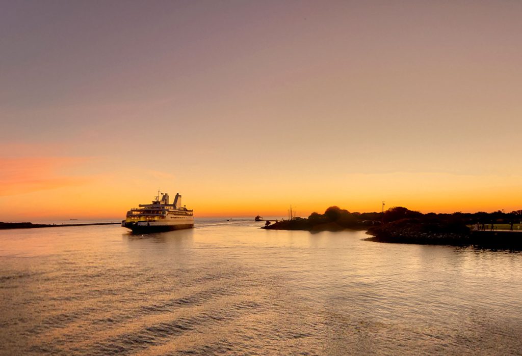 The Ferry enters the Cape May Canal, backlit by a colorful sunset